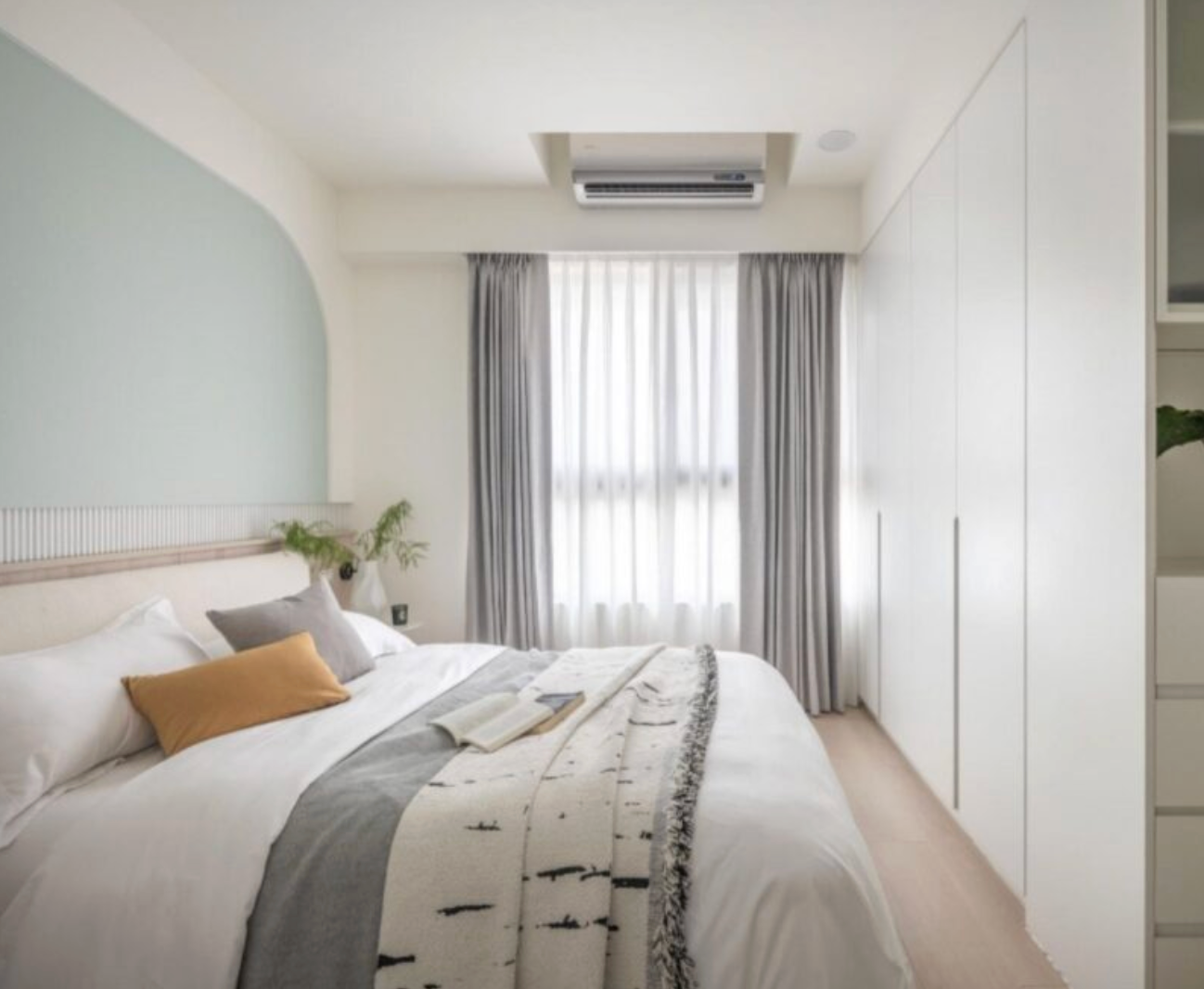 現代風格臥室內的雙層窗簾：外層灰色布簾、內層白色柔紗簾，搭配薄荷綠弧形床頭牆與白色衣櫃，展現靜謐與高質感